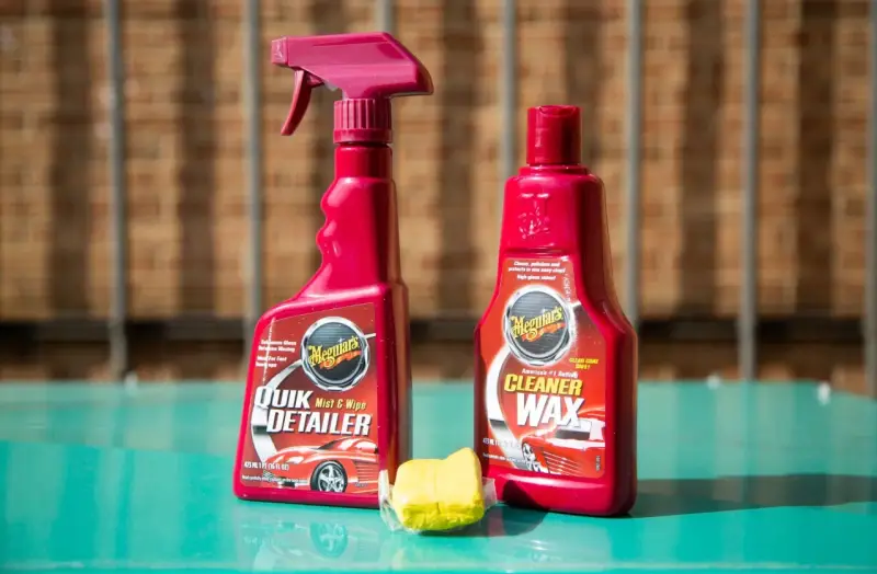 Car detailing supplies: Meguiar's Quik Detailer, Cleaner Wax, and a clay bar for a smooth finish.